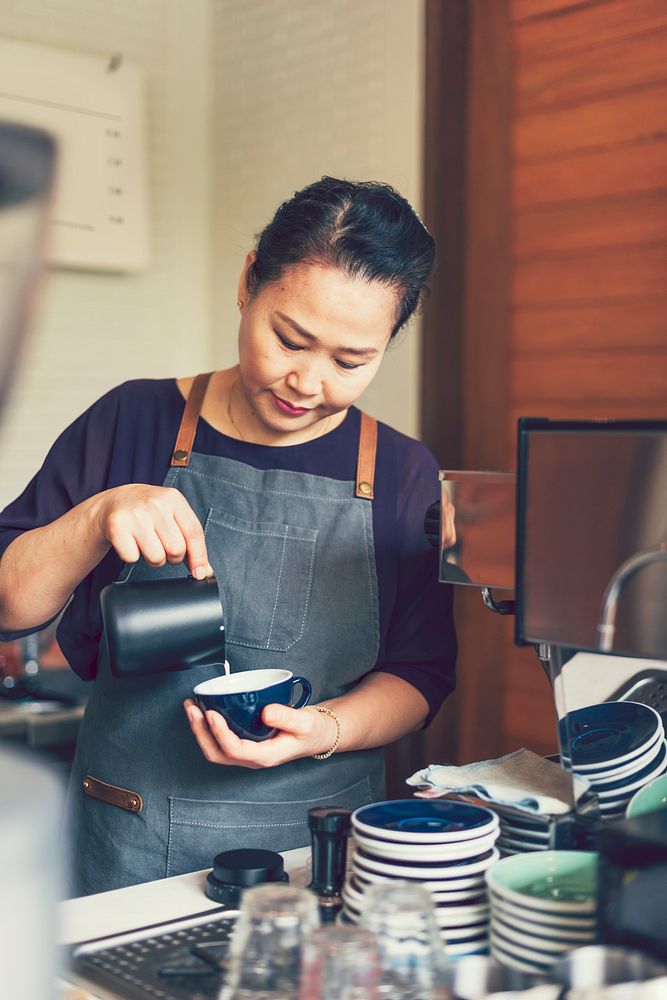 Asian barista creating latte art