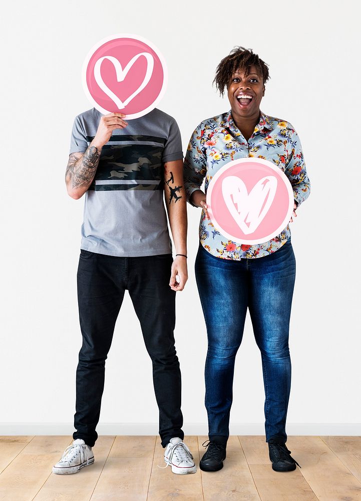 Interracial couple holding valentine's icons