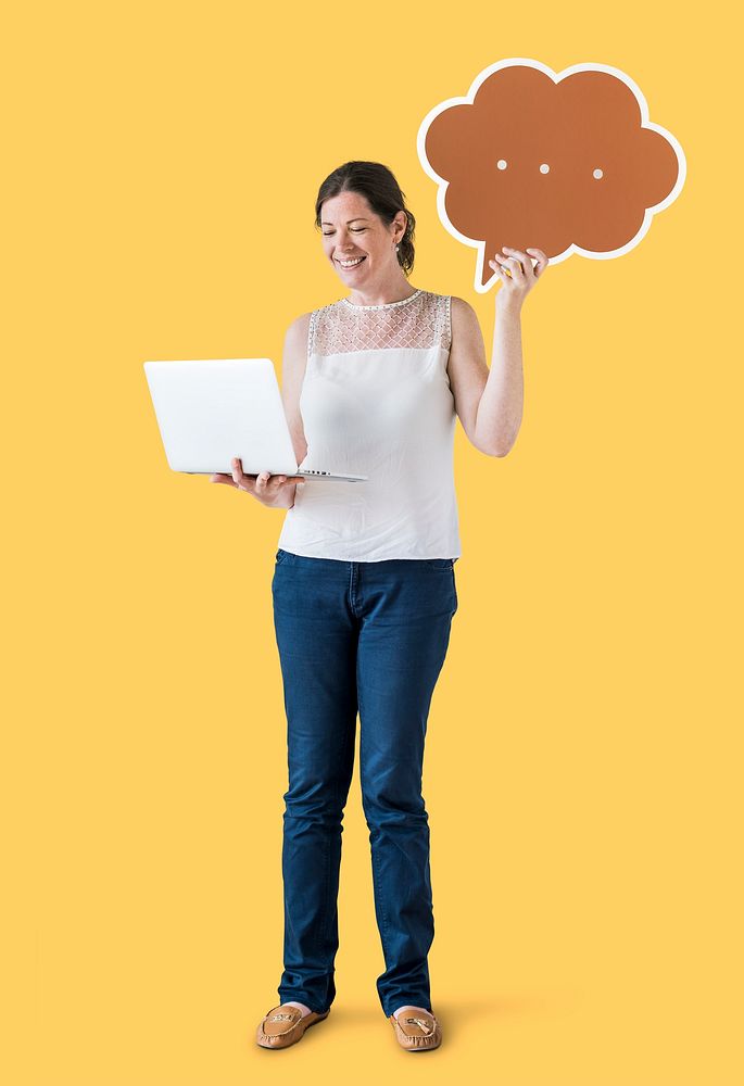 Woman holding a speech bubble and using a laptop