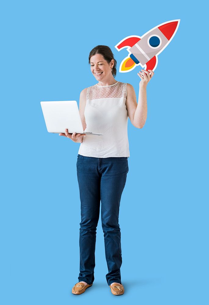 Woman holding a rocket icon and using a laptop