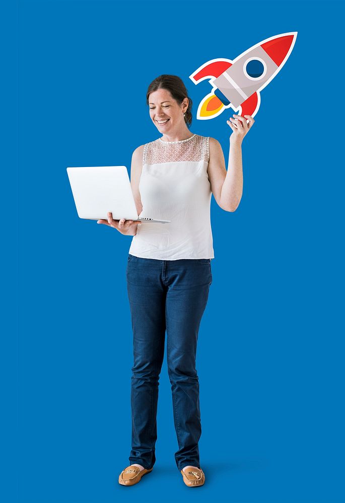 Woman holding a rocket icon and using a laptop