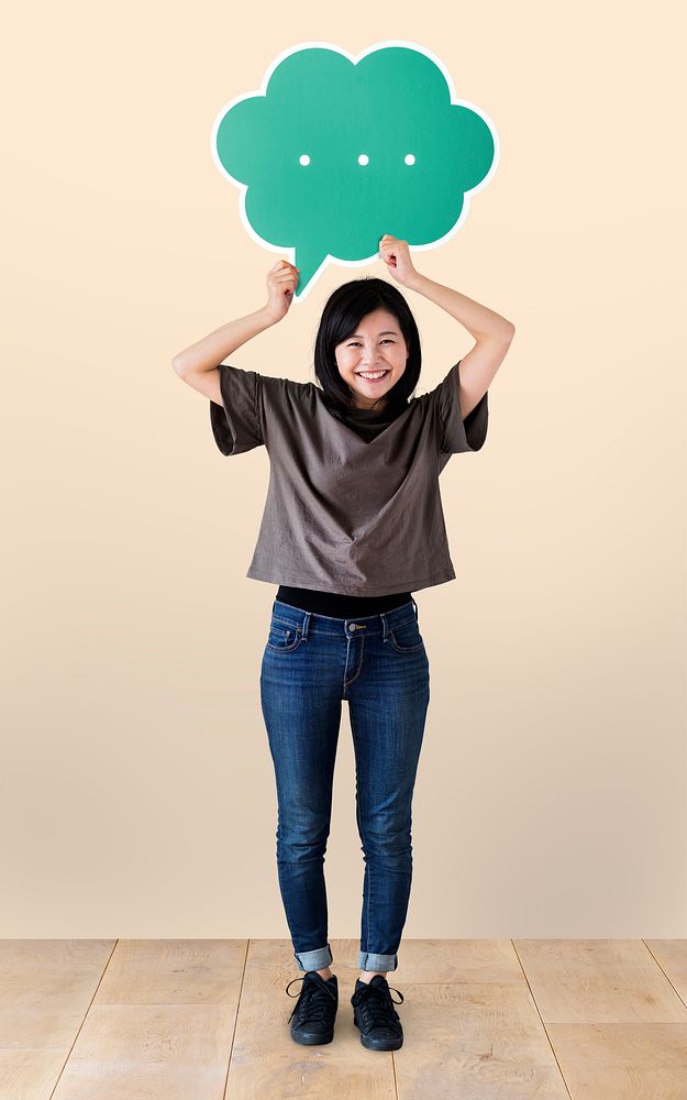 Cheerful woman holding a green speech bubble