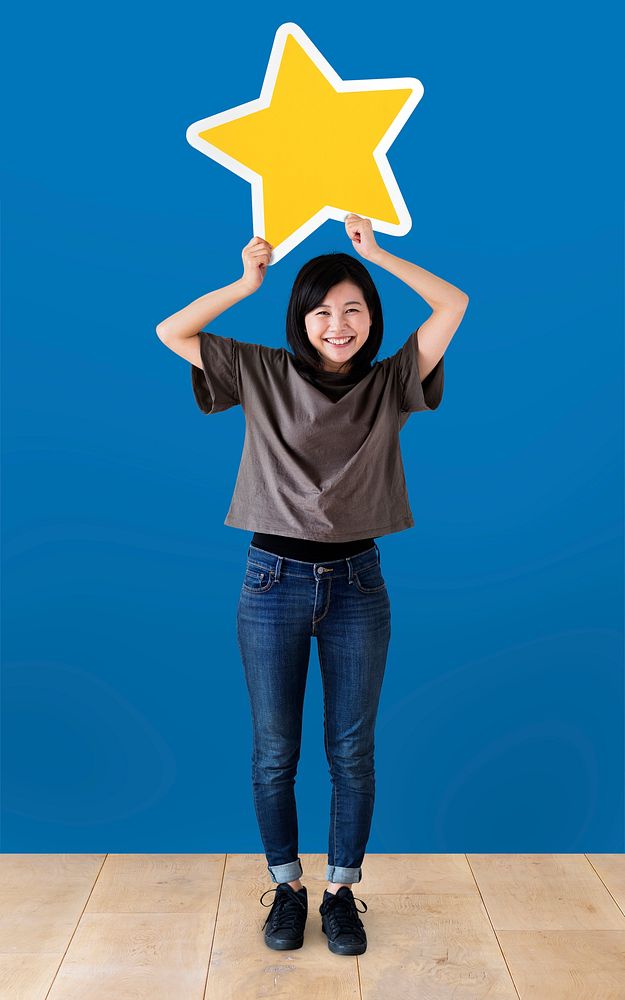Cheerful woman holding a golden star icon