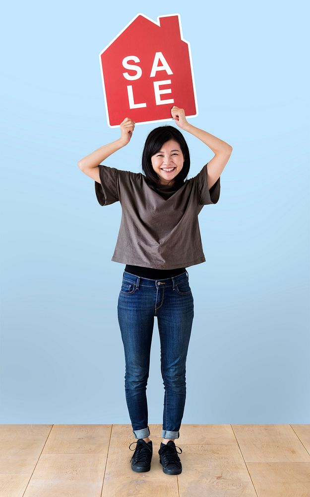 Cheerful woman holding a house sales icon