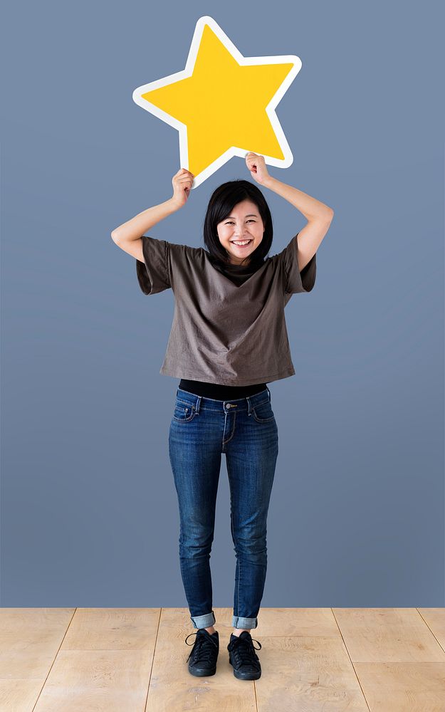 Cheerful woman holding a golden star icon