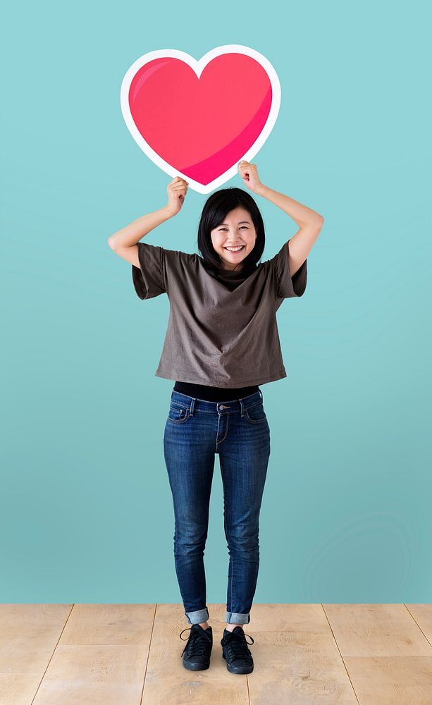 Cheerful woman holding a heart icon
