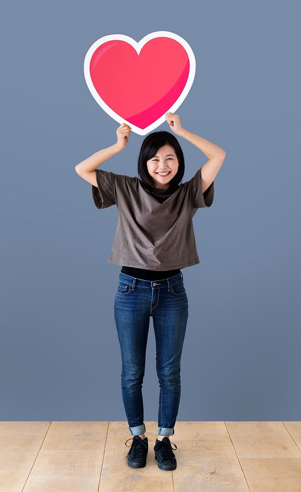 Cheerful woman holding a heart icon