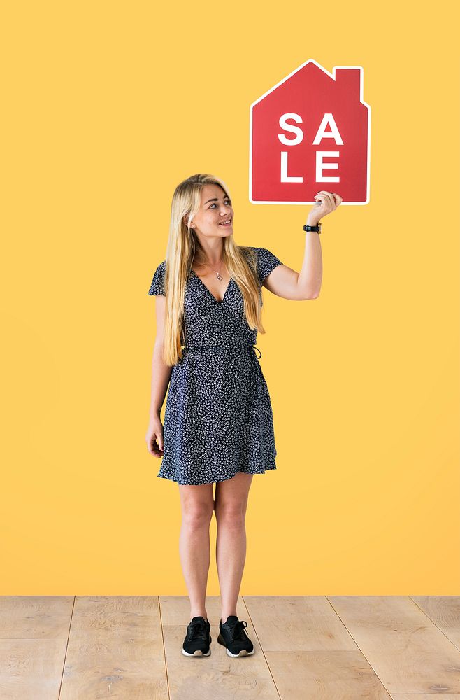 Cheerful woman holding a house sales icon