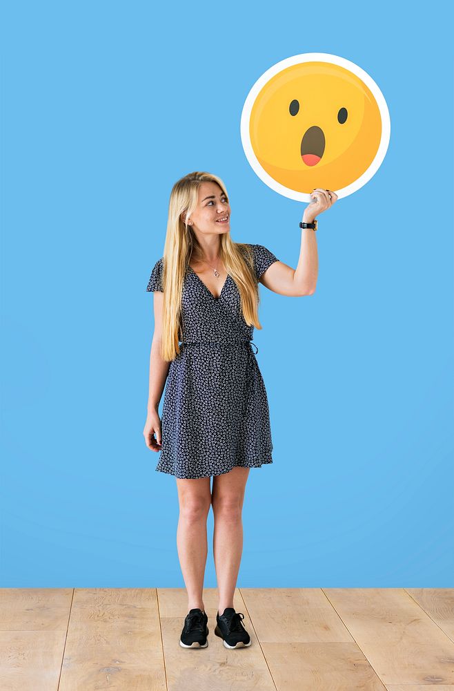 Cheerful woman holding a surprised emoticon