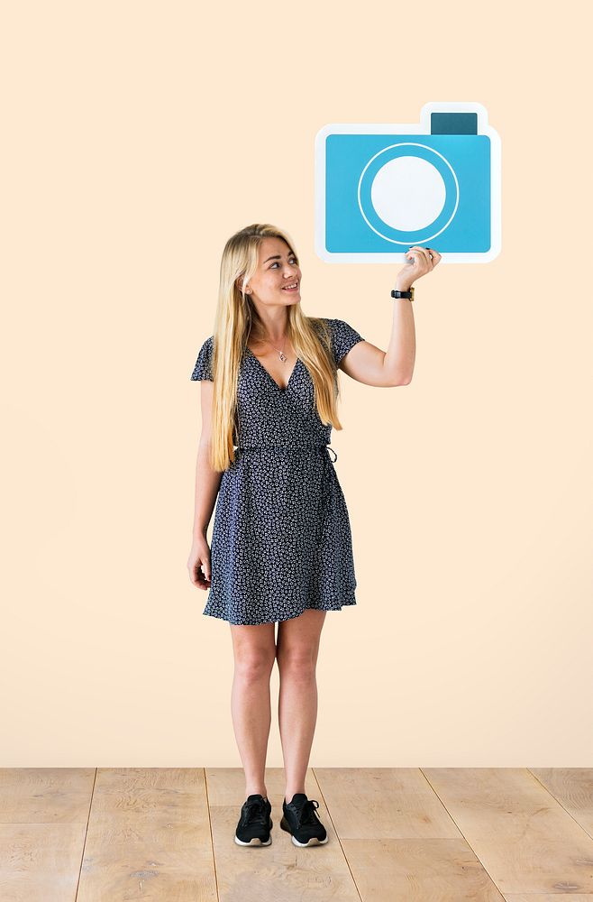 Cheerful woman holding a blue camera icon