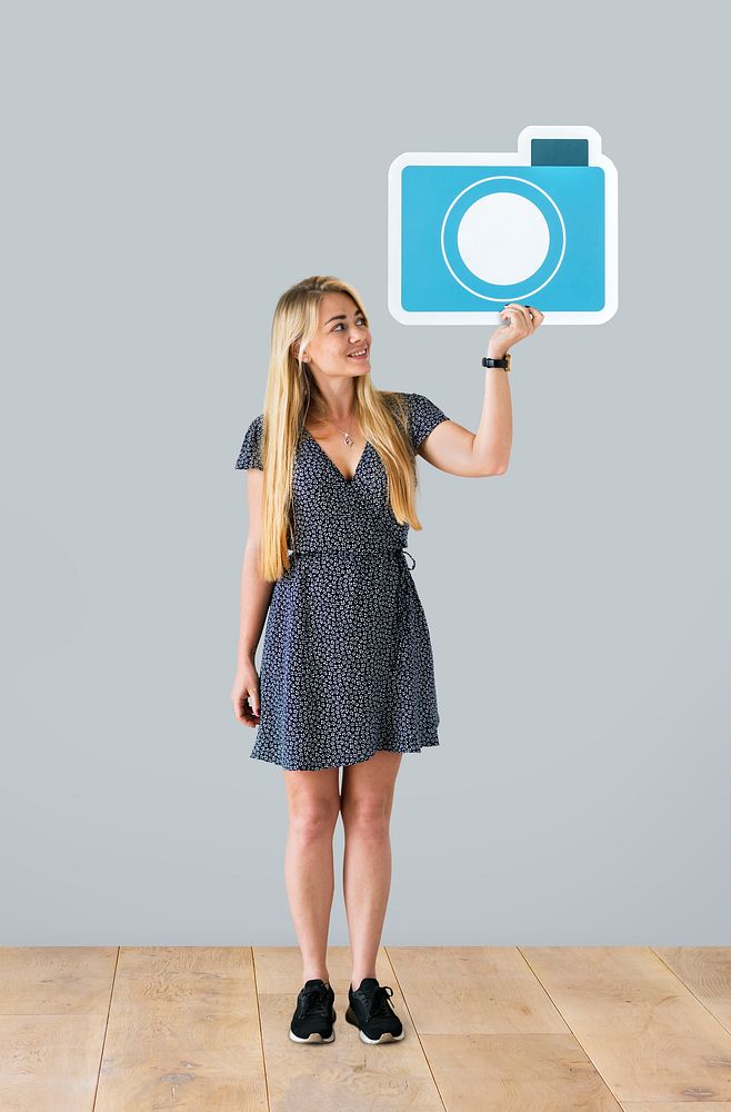Cheerful woman holding a blue camera icon