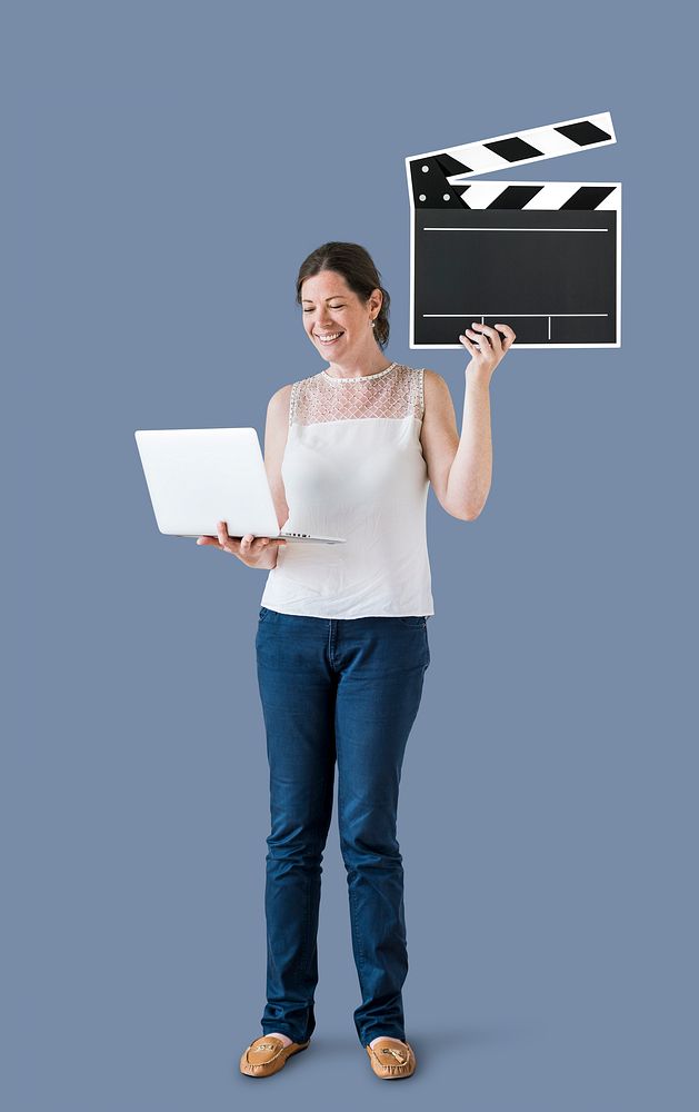 Standing woman holding a clapper and a laptop