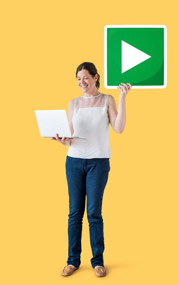 Standing woman holding a play button and a laptop