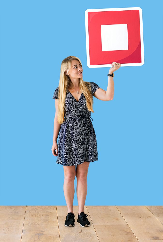 Woman holding a stop button icon in a studio