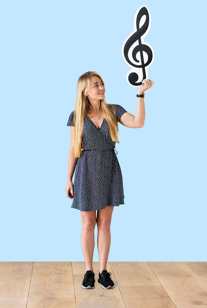 Woman holding a musical note in a studio