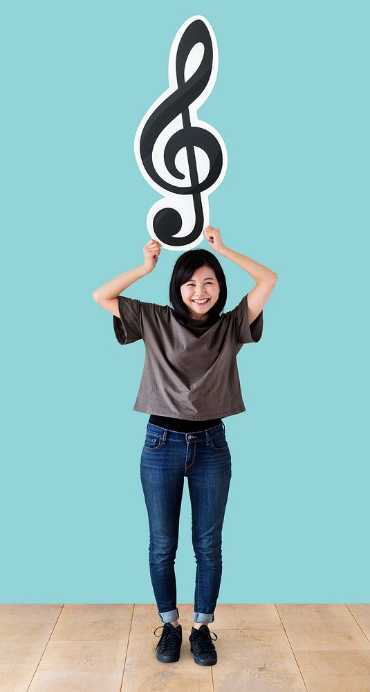 Woman holding a musical note in a studio