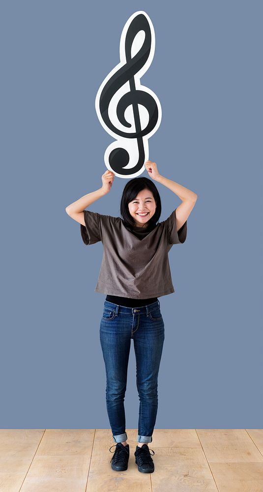 Woman holding a musical note in a studio