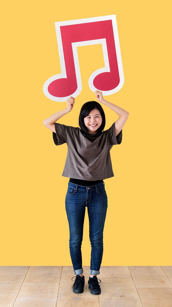 Woman holding a musical note icon in a studio