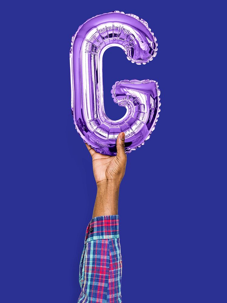 Hand holding balloon letter G