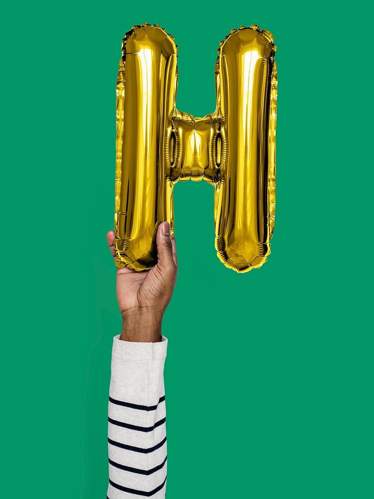 Hand holding balloon letter H