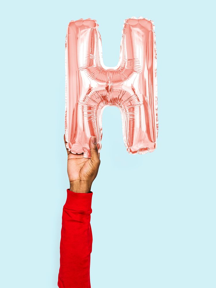 Hand holding balloon letter H