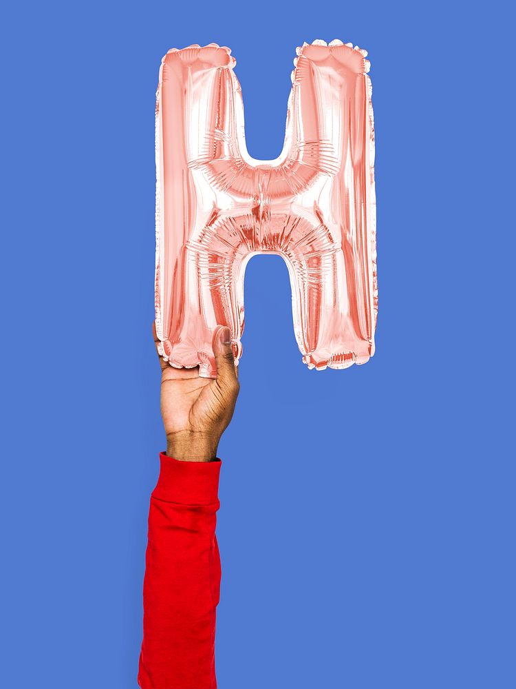 Hand holding balloon letter H
