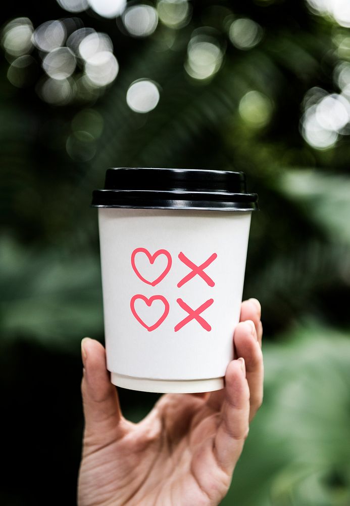 Hearts and kisses symbols on a paper coffee cup