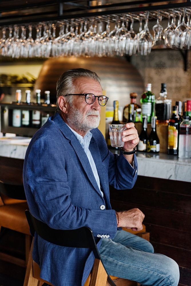 Elderly man is sitting in a pub