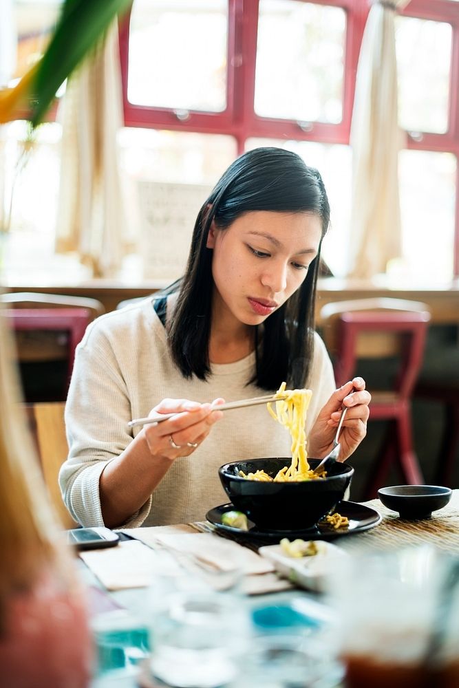 Asian woman eating noodles
