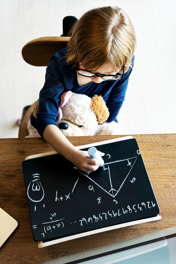 Cute little girl drawing on a blackboard