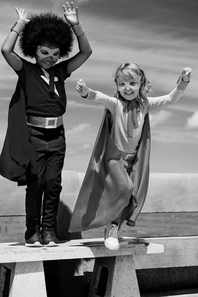 Boy with an afro and a blonde girl in superhero costumes