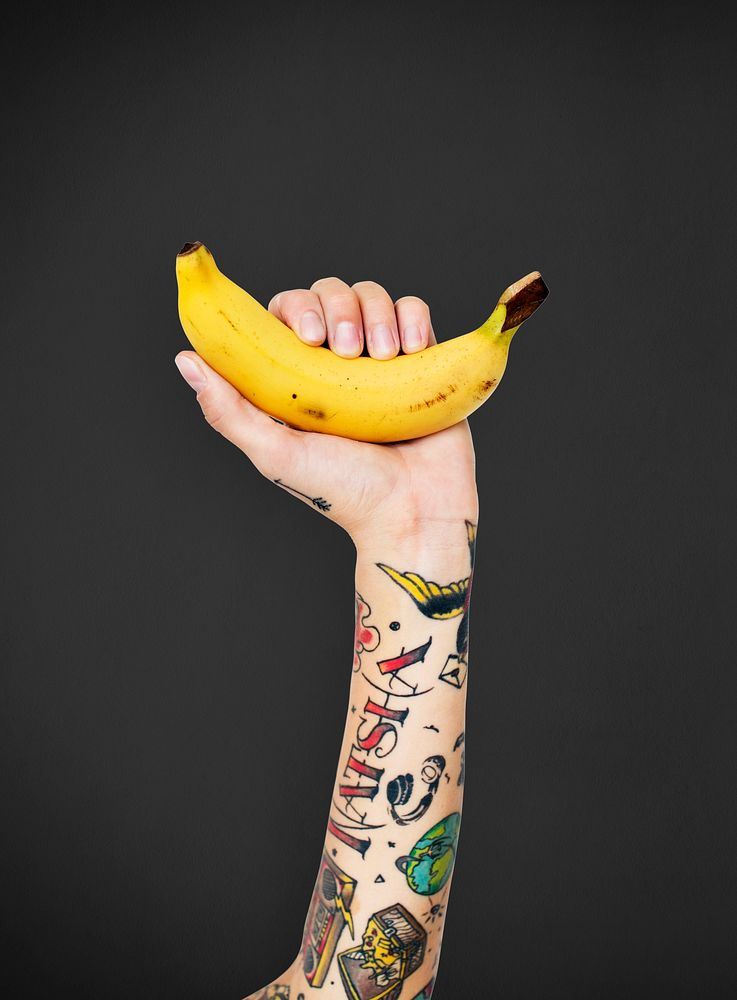 Tattooed woman holding a banana
