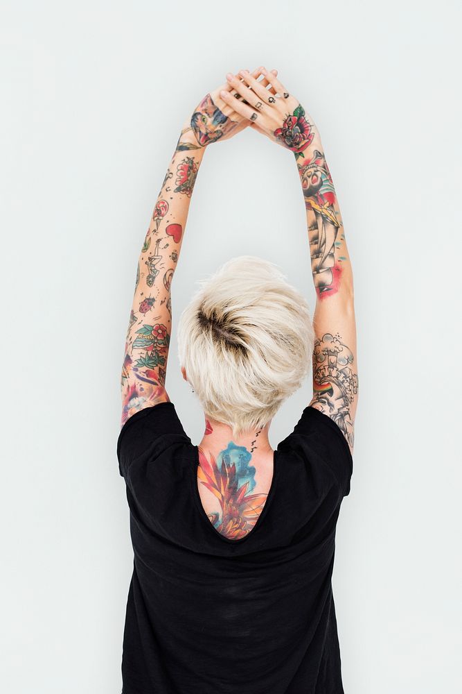 Tattooed blonde woman stretching her arms