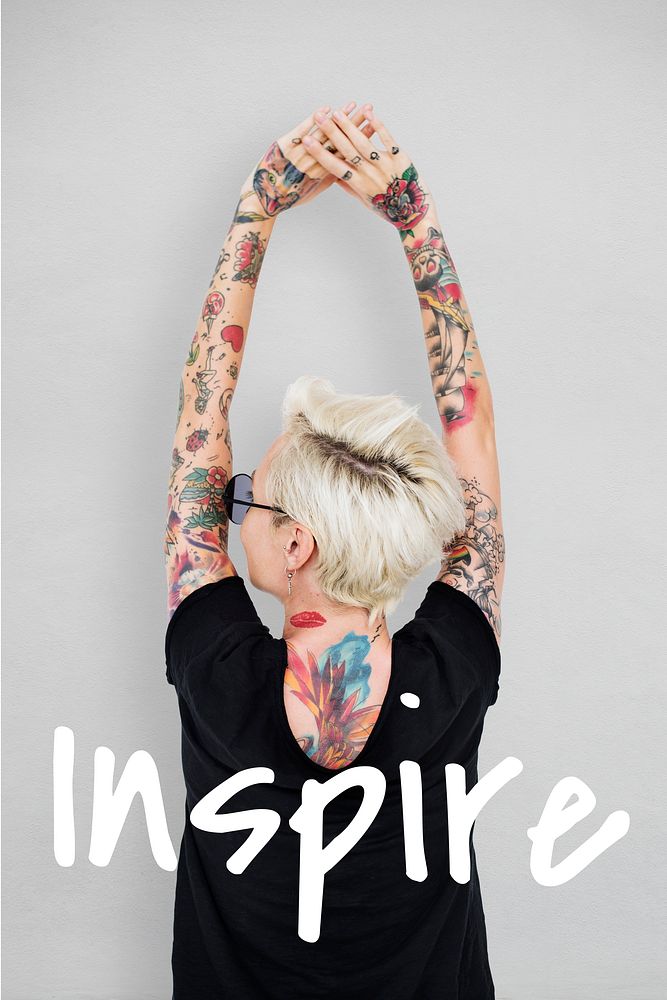 Rear view of tattooed woman in black tee with inspire word
