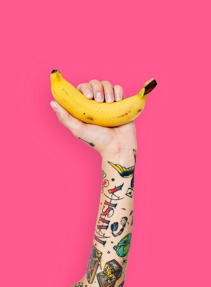 Tattooed hand holding a banana