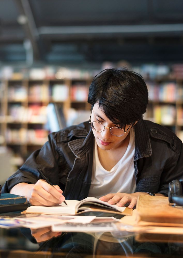Asian student boy studying in school library