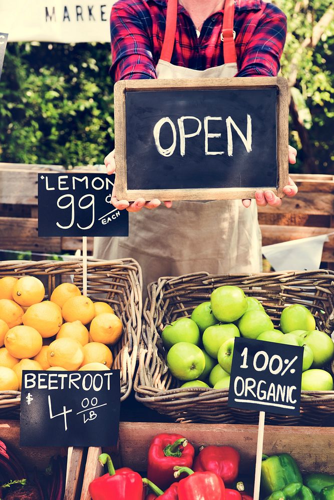 Greengrocer selling organic fresh agricultural product at farmer