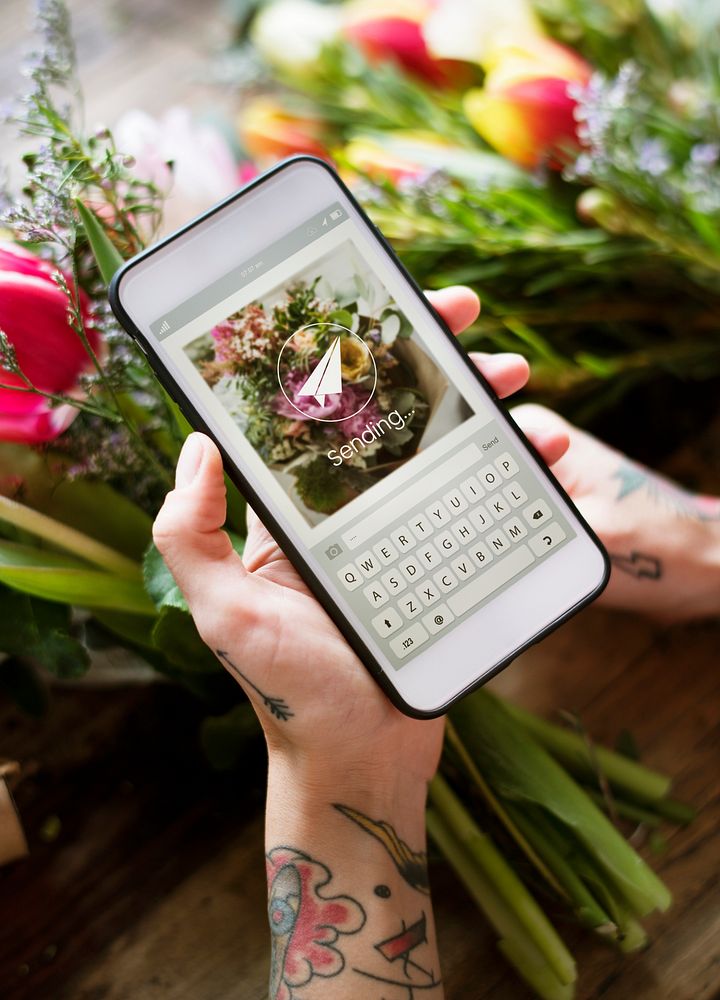 Hand taking a photo of flowers with phone camera