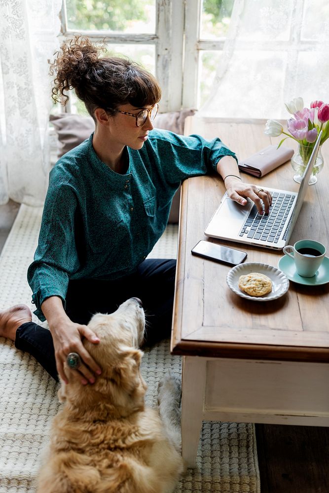 Woman using laptop on leisure day with golden retriever