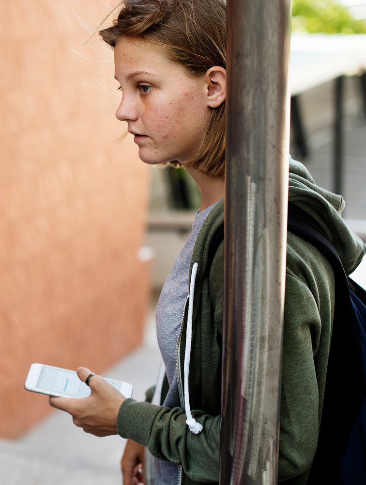 Caucasian student girl standing holding smart phone