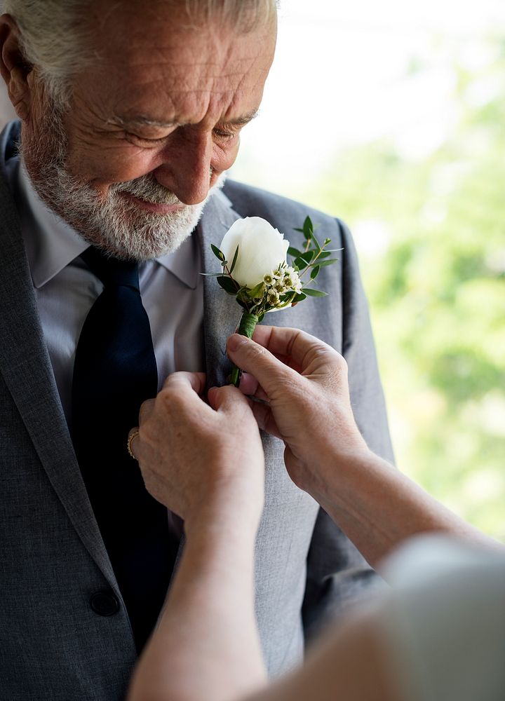 Hands Put on Small Flower Bouquet on Tuxedo