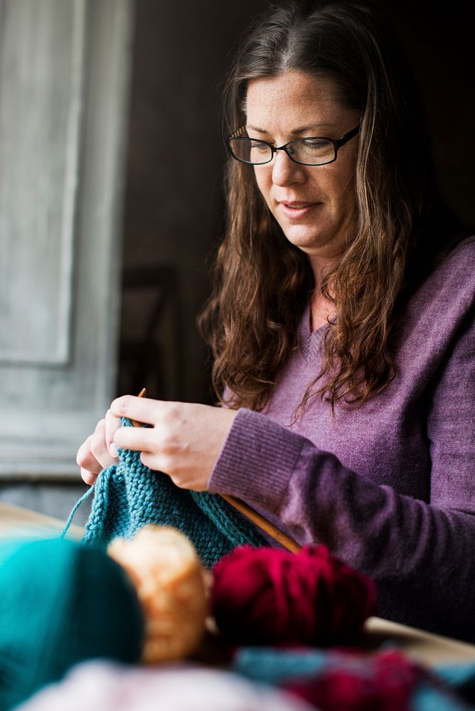 Caucasian woman leisure knitting on wooden table
