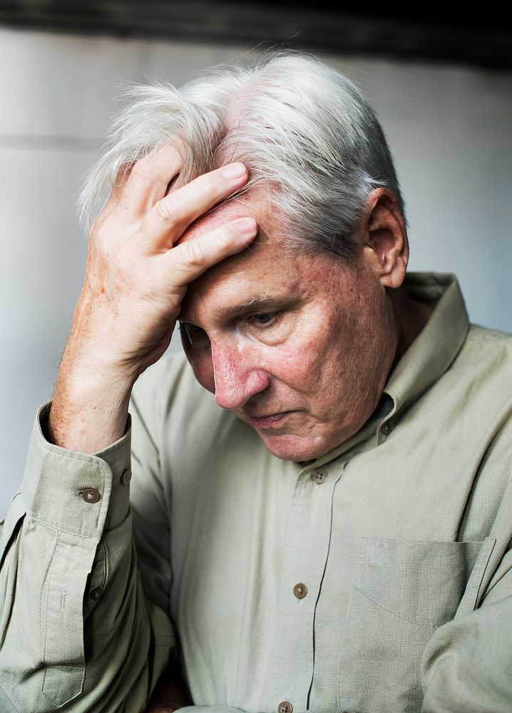 Elderly caucasian man with his hand on his head