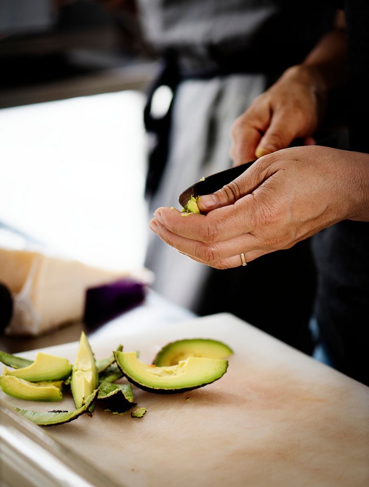Closeup of hands peeling avocado