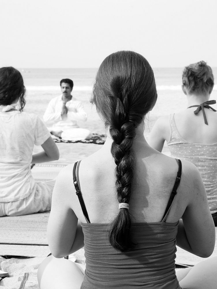 Yoga instructor and his students by the beach.