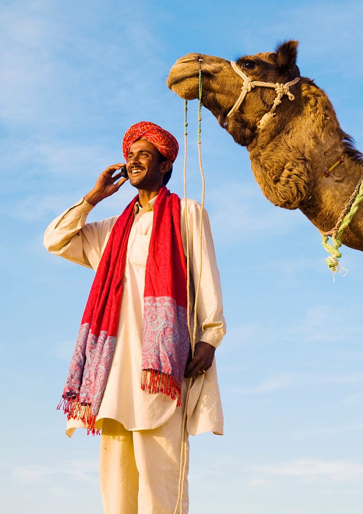 Indian man with camel making a call