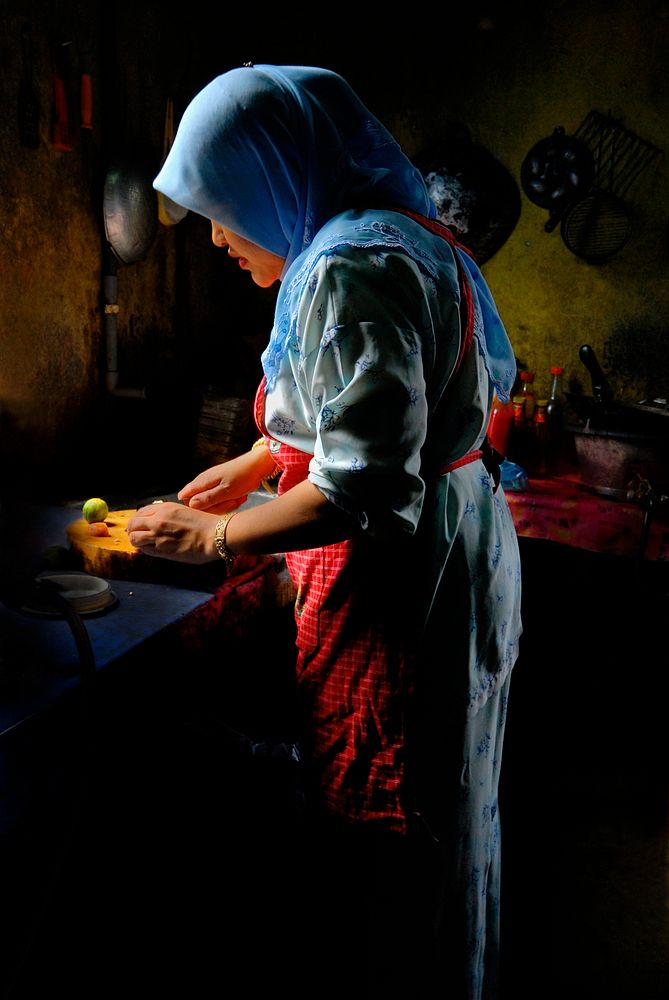 Malaysian lady using natural sunlight to prepare food in the kitchen