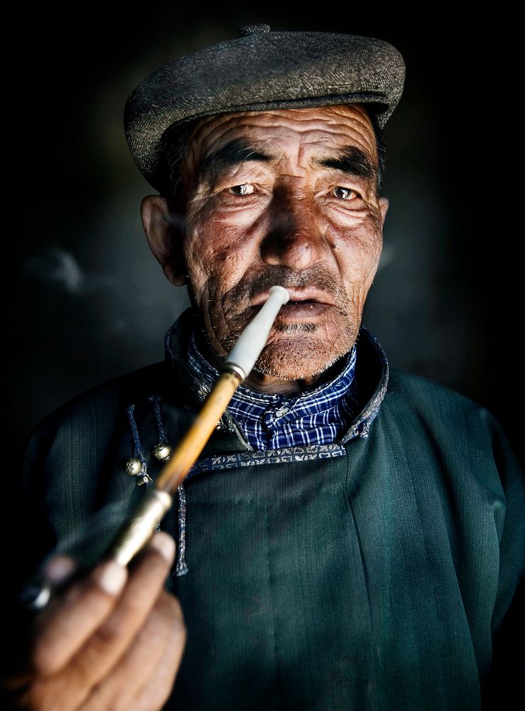Mongolian man smoking a pipe