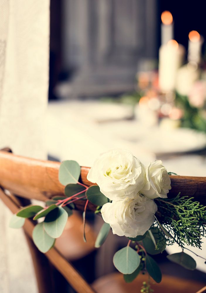 White Roses Wrapped on Wooden Chair Decorate on Wedding Receptio