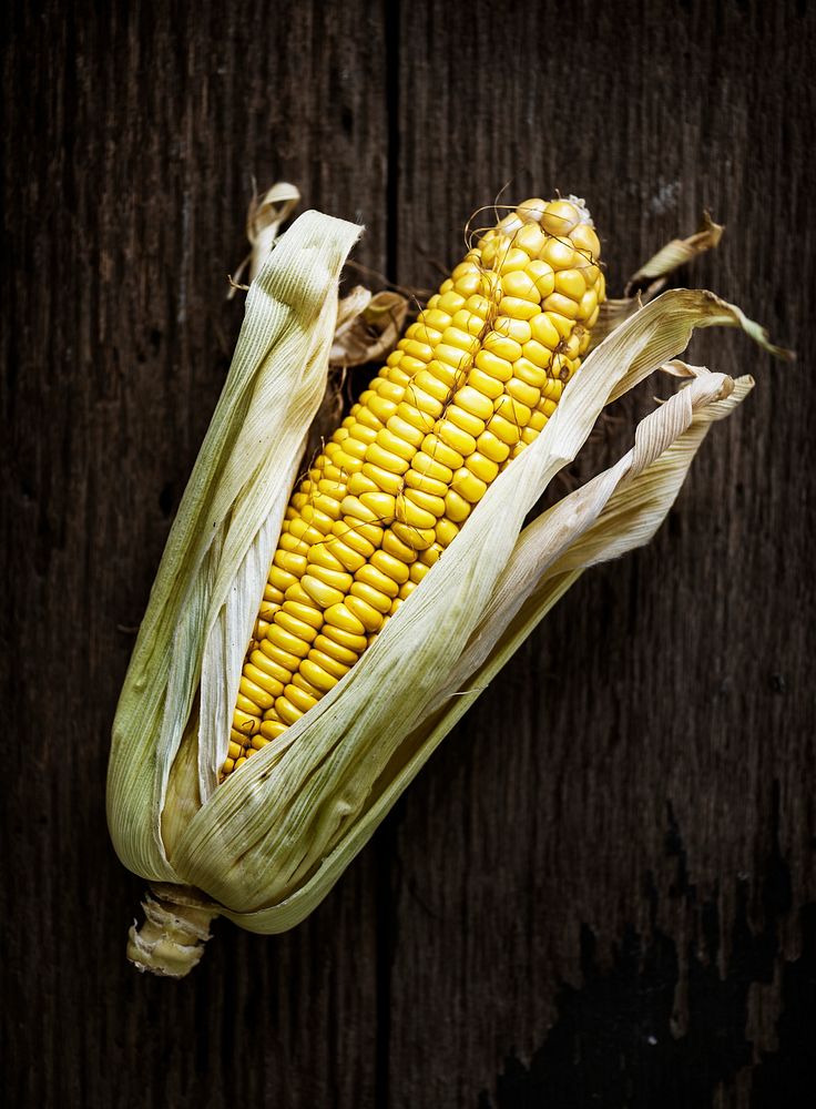 Aerial view of sweencorn cob on wooden background